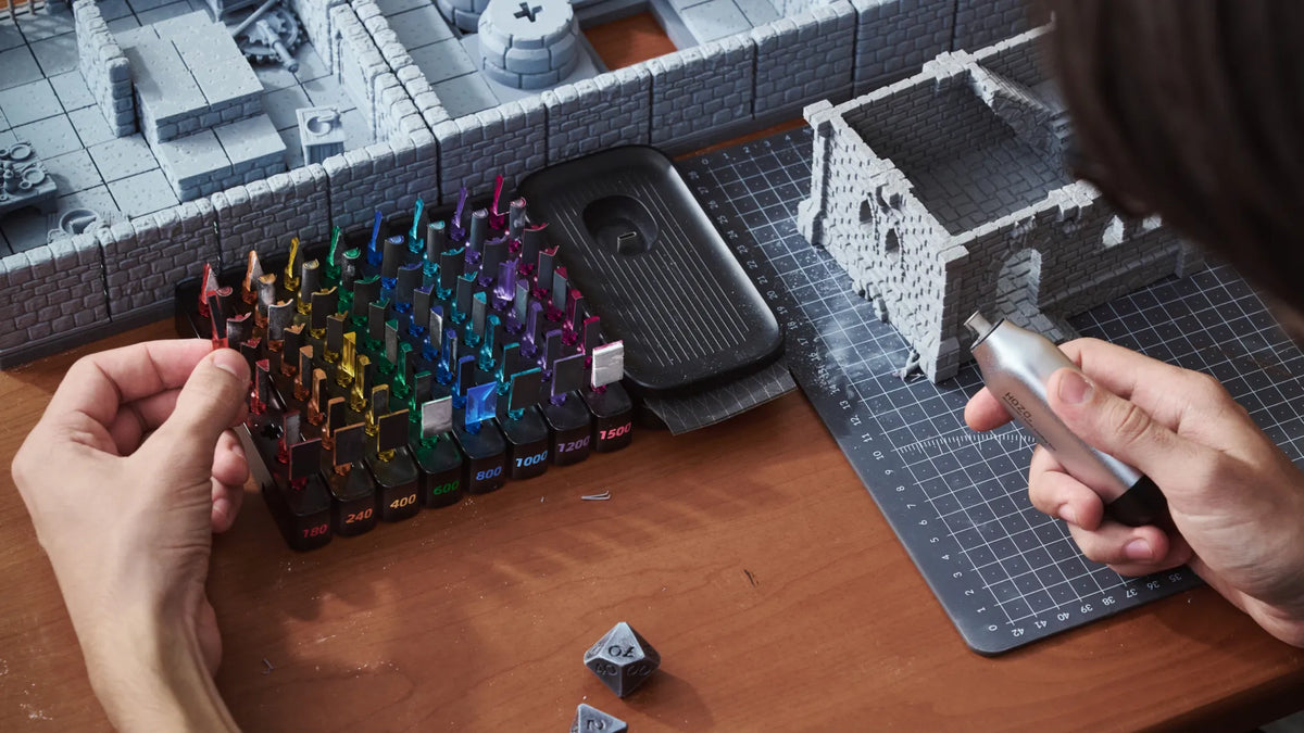 Color-coded sanding heads set beside 3D printed tabletop terrain