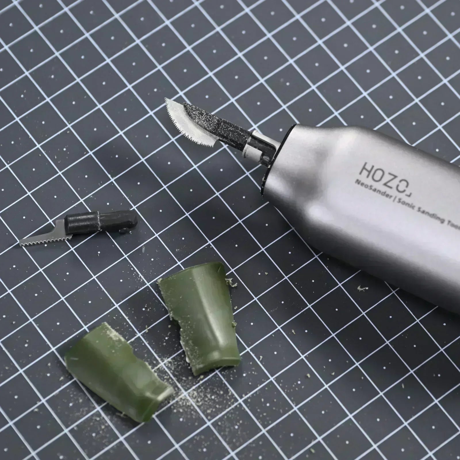 NeoSander Precision Saw with saw blade cutting green material on a grid cutting mat